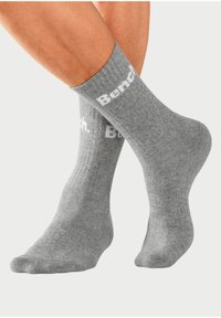 Graue Baumwollsocken mit gerippter Textur und dem weißen "Bench."-Logo, das nahe dem Bündchen aufgedruckt ist. Knöchellanges Design. Weiche und angenehme Passform.