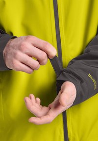 Wasserdichte Jacke mit einem leuchtend gelben Körper und dunkelgrauen Ärmeln. Verfügt über verstellbare Bündchen mit Klettverschluss und einen Reißverschluss vorne.