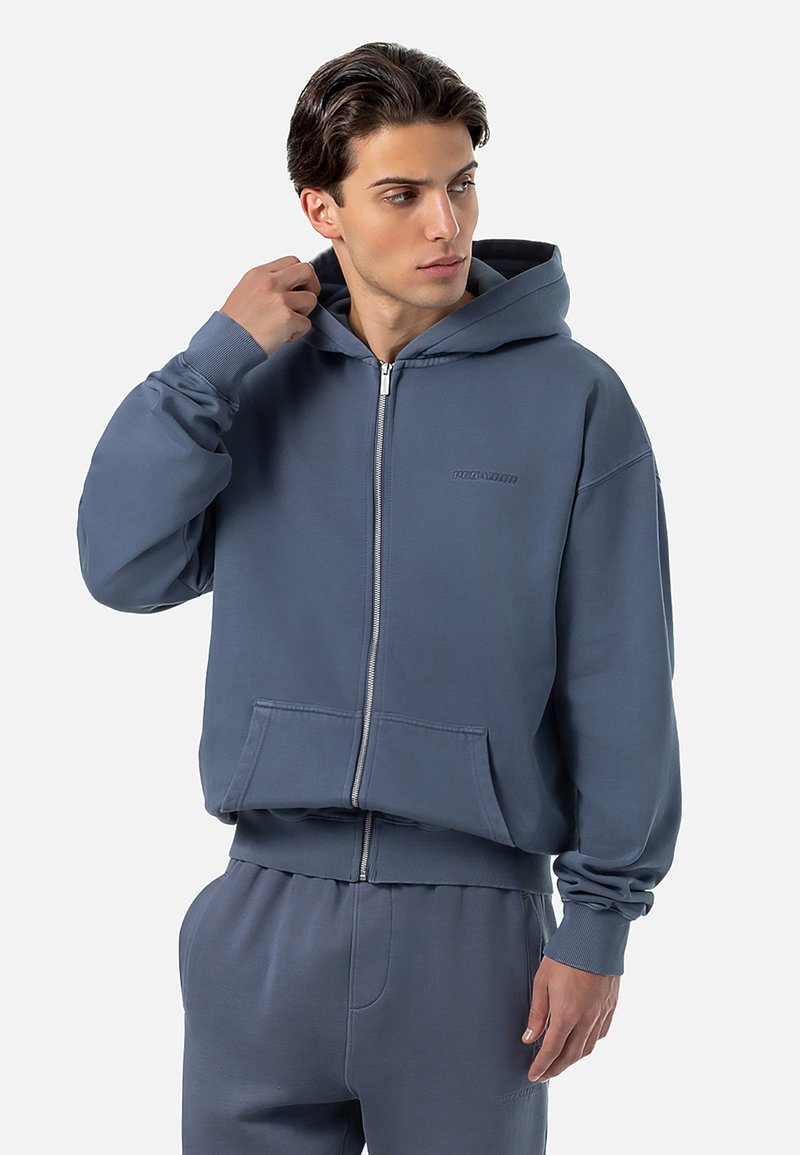 Sweatshirt com capuz e fecho, em tecido azul suave, com um bolso canguru e punhos canelados. Apresenta um detalhe de logótipo discreto no peito.
