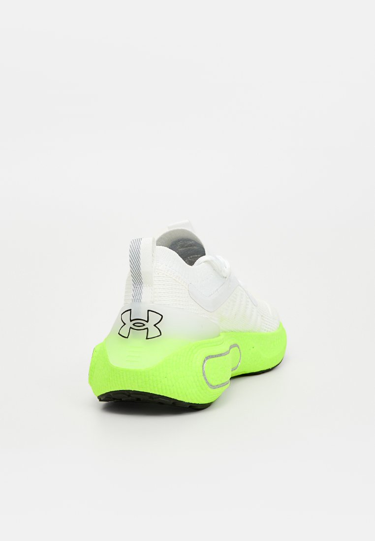 Basket de sport blanche avec une tige texturée, une semelle extérieure noire et une semelle verte fluo. Présente un logo sur le côté et une sangle pour un maintien sécurisé.