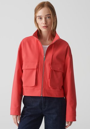Koraal kleurige cropped jack gemaakt van soepel materiaal, met een hoge kraag, twee grote voorzakken en een volledige ritssluiting.