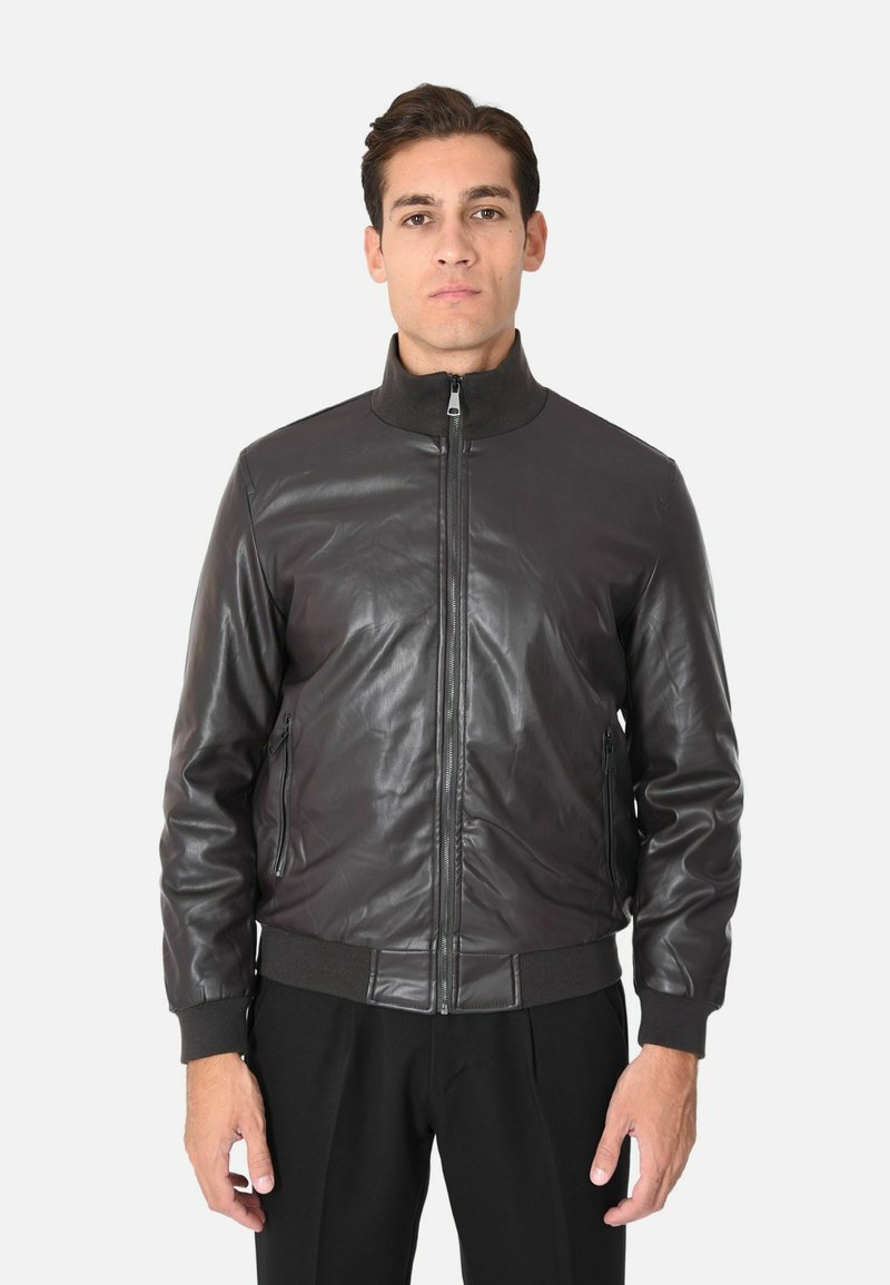 Giubbotto bomber in pelle marrone scuro, chiusura con zip, polsini e vita a coste, texture liscia, tasche laterali, design con collo alto.