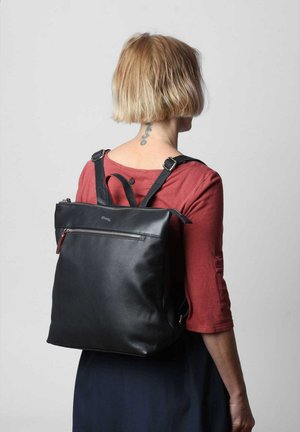 Zaino in pelle nera con zip superiore, spallacci regolabili e tasca frontale. Texture liscia e forma rettangolare.