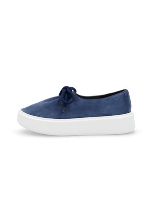 Zapato azul marino de ante sin cordones con suela gruesa blanca de goma y lazo de cuerda azul marino en la parte superior, visto de perfil.
