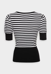 Haut en tricot rayé noir et blanc avec manches courtes, taille cintrée et texture côtelée. Ourlet et manches noirs unis.
