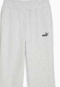 Ljusgrå sweatpants i mjukt tyg, med elastisk midja och en svart Puma-logotyp på vänster lår.