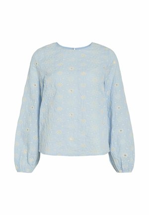 Chemisier bleu clair à manches longues avec col rond, orné de broderies florales ajourées blanches et de poignets élastiques.