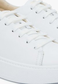 Witte leren sneakers met platte veters, een gladde textuur en een ronde neus. Voorzien van een rubberen zool en minimalistische designelementen.