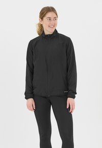 Svart lättviktsjacka med hög krage, hel dragkedja och elastiska ärmslut. Har en slät textur och en figursydd design, lämplig för aktiv användning.