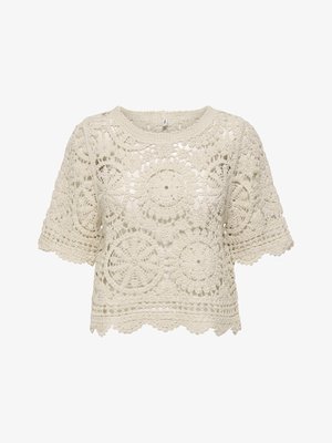 Top en crochet crème à manches courtes avec motifs circulaires et floraux, ourlet et encolure festonnés, texture semi-transparente.