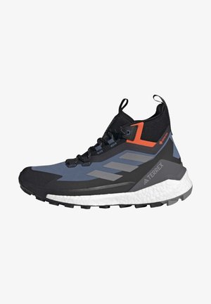 Zapatilla deportiva de caña alta con una mezcla de colores negro, azul y naranja, con un upper texturizado, diseño de tres rayas y una suela blanca acolchada.