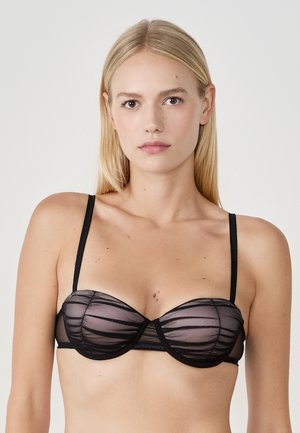Zwarte beha met een doorschijnende mesh overlay met horizontale strepen, voorzien van beugelsteun en verstelbare bandjes. Gladde textuur met een subtiele glans.