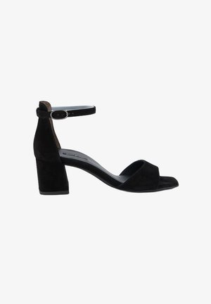 Le sandali con tacco in suede nero presentano un design open-toe, una cinghia alla caviglia con fibbia in metallo e un tacco a blocco spesso per garantire stabilità.