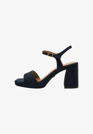 Navyblaue Wildleder-Blockabsatzsandalen mit offener Zehe, verstellbarem Knöchelriemen und chunky Blockabsatz. Goldfarbene Schnallenverzierung.