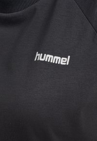 Zwarte sweatshirt met een geribbelde ronde hals, voorzien van een witte "hummel" logo aan de voorkant. Zachte textuur en minimalistisch ontwerp.