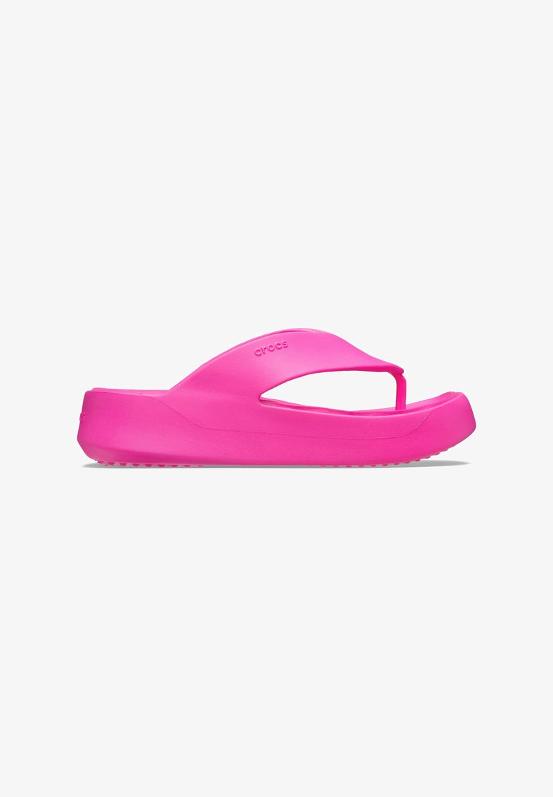 Roze rubberen flip-flop sandaal heeft een breed strapdesign, een gestructureerde voetbed en een vlakke zool met kleine gripnoppen voor meer grip.