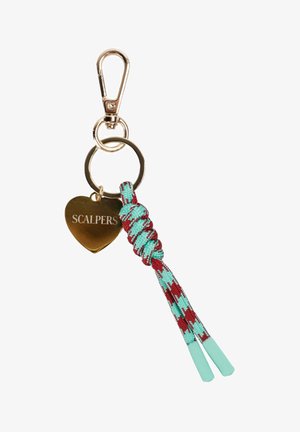 Llavero de metal dorado con clip, etiqueta en forma de corazón grabada con "SCALPERS," y cordón trenzado anudado en azul verdoso y rojo.