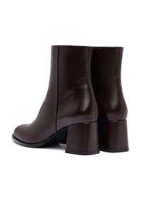 Bruine leren enkelboots met een gladde afwerking, ronde neus en stevige blokhakken. Inclusief een verticale naaddetail aan de achterkant.