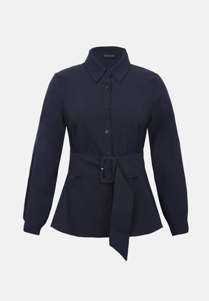 Granatowa, długorękawowa koszula zapinana na guziki, z ostrym kołnierzykiem i szerokim materiałowym paskiem z prostokątną klamrą w talii.