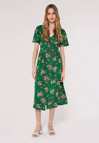 Grünes Blumenkleid mit kurzen Ärmeln, geraffter Taille, Midi-Länge und einem lebhaften Druck mit pinken, orangen und weißen Blumen.