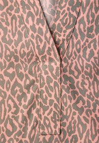 Tissu imprimé léopard rose et gris avec un col en V et une patte de boutonnage cousue. Texture lisse avec des formes de motif variées.