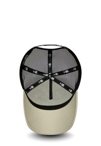 Trucker cap with a beige brims and mesh black back. Features a structured design with an adjustable strap and logo accents on the fabric.