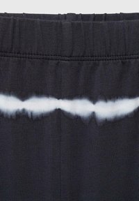Črn elastični pas z nabranim teksturo, ki ima bel tie-dye vzorec na sredini, prehajajoč iz temnih v svetle tone.