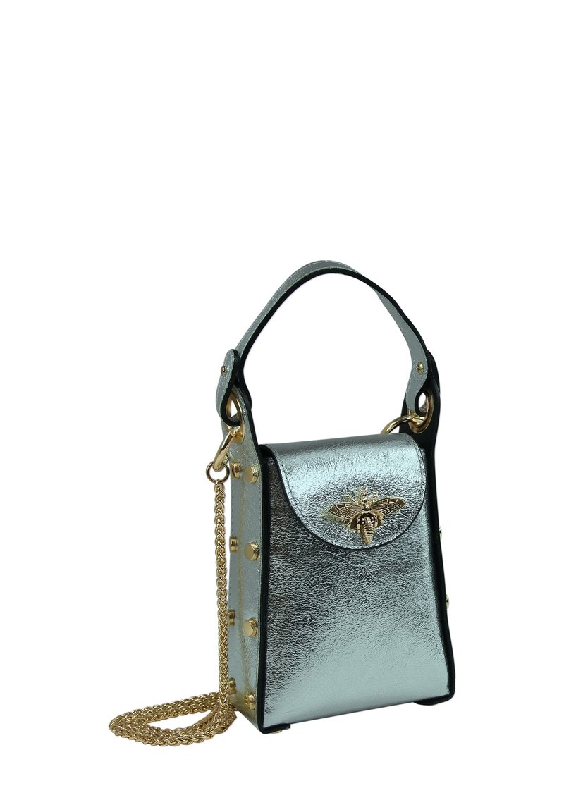 Metallic zilveren handtas met een rechthoekige vorm. Voorzien van een goudkleurige bijen-sluiting, gouden studs aan de zijkanten en een afneembare kettingriem.