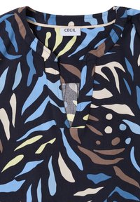 Blouse en tissu foncé avec une fente au niveau du col ; présente des motifs abstraits en bleu, beige, marron et jaune. Étiquette de la marque « CECIL » au niveau du col.