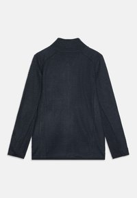 Veste bleu marine foncé avec un motif en zigzag texturé, col haut, manches longues et poignets élastiques subtils. Pas de matériel visible.