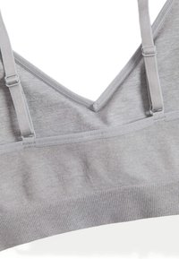 Bralette grigio con design a V, realizzato in tessuto morbido. Presenta spalline regolabili e un band in tessuto a coste testurizzato.