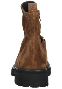 Botine din suede brown cu finisaj texturat, având o talpă din cauciuc negru și detalii cusute. Închidere cu fermoar și logo la spate.