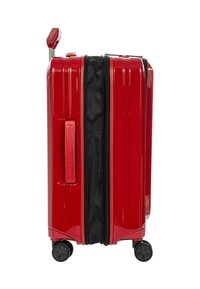 Valigia rigida rossa con zip espandibile nera, quattro ruote piroettanti nere e un manico telescopico rosso estensibile.