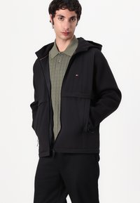 Tommy Hilfiger PERFORMANCE MIXMEDIA WINDBREAKER - Chaqueta de entretiempo - black