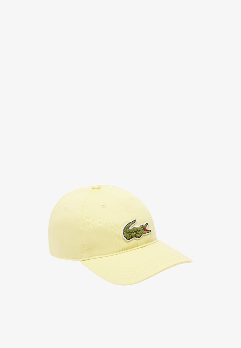 Yellow cotton cap with a curved brim, featuring a green and red embroidered crocodile logo on the front. Six-panel design with eyelets.