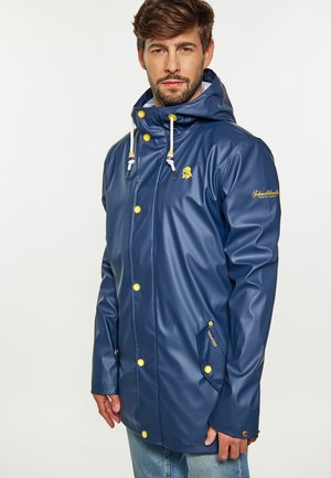 Navy blue waterproof coat with yellow buttons and drawstrings; features a zippered pocket and logo detail on sleeve; smooth texture.