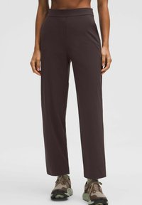 Barna, magas derekú, bő szárú nadr�ág sima anyagból. Letisztult vonalvezetés jellemzi, és textúrált cipőkkel párosították.