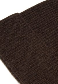 Tejido de lana de color marrón oscuro, texturizado y acanalado, con una sensación suave. Bordes ligeramente doblados, mostrando un patrón consistente a lo largo del material.