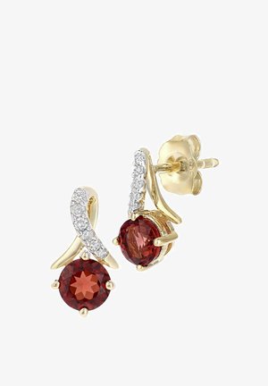 Złote kolczyki z czerwonymi owalnymi kamieniami szlachetnymi, ozdobione przejrzystymi kamieniami wzdłuż skręconego wzoru, zabezpieczone zatrzaskiem motylkowym.