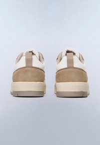 Sneakers in suede beige e pelle crema con forma arrotondata, dotati di una soletta imbottita e di un'etichetta sul retro per facilitarne l'indossamento.