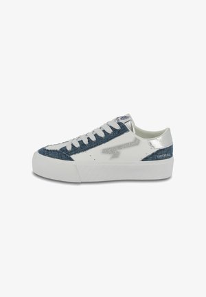 White sneakers with a denim accent, metallic silver details, and a textured sole. Features lace-up closure and a logo on the heel.