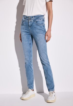 Lichtblauwe skinny jeans van denim met twee voorzakken en een tweeknoopsluiting. Draagt met witte sneakers voor een casual uitstraling.