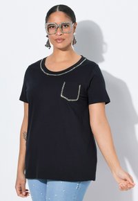Camiseta negra de manga corta con un escote redondeado, acentos de cristal a lo largo del escote y el bolsillo. Tejido suave con un ajuste relajado.