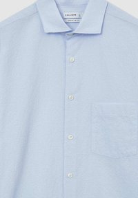 Camicia azzurra chiara a maniche corte realizzata in tessuto testurizzato. Caratterizzata da un colletto classico, una chiusura con bottoni e una tasca sul petto. Vestibilità regolare.