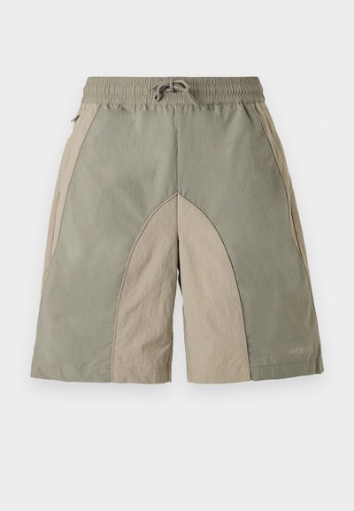 Kerged lühikesed püksid elastse vöökohtaga, millel on oliivroheliste ja beežide paneelide segu ning tekstureeritud viimistlus.