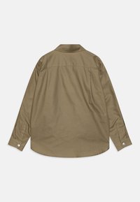 Olivno zelena majica z dolgimi rokavi in ovratnikom, s curved hem in gumbi na koncu rokavov. Ima gladko teksturo tkanine in detajl na zadnjem delu.