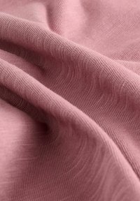Weiche, strukturierte Stoff in zartem Rosé, mit einem subtilen Wellenmuster und einer leichten, leicht dehnbaren Zusammensetzung.