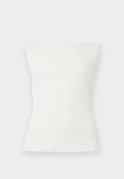 Λευκό τοπ χωρίς τιράντες με υφή πλεξίματος, εφαρμοστή σιλουέτα και διακριτικό μοτίβο κυψελίδας.