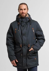 Parka noire avec capuche à cordon de serrage, fermetures éclair et boutons, accents beige, deux poches avant et doublure intérieure chaude.
