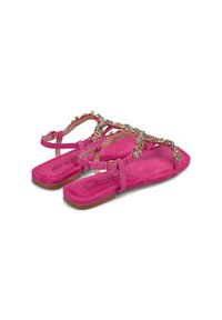 Sandali in suede rosa con suola piatta, design a T con decorazioni di gemme colorate e cinturino alla caviglia regolabile.